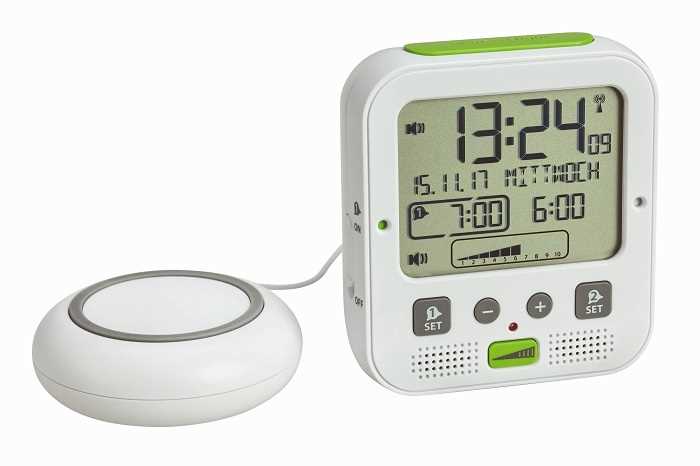 Weißer Funkwecker mit großem Display und angeschlossenem rundem Vibrationskissen links daneben