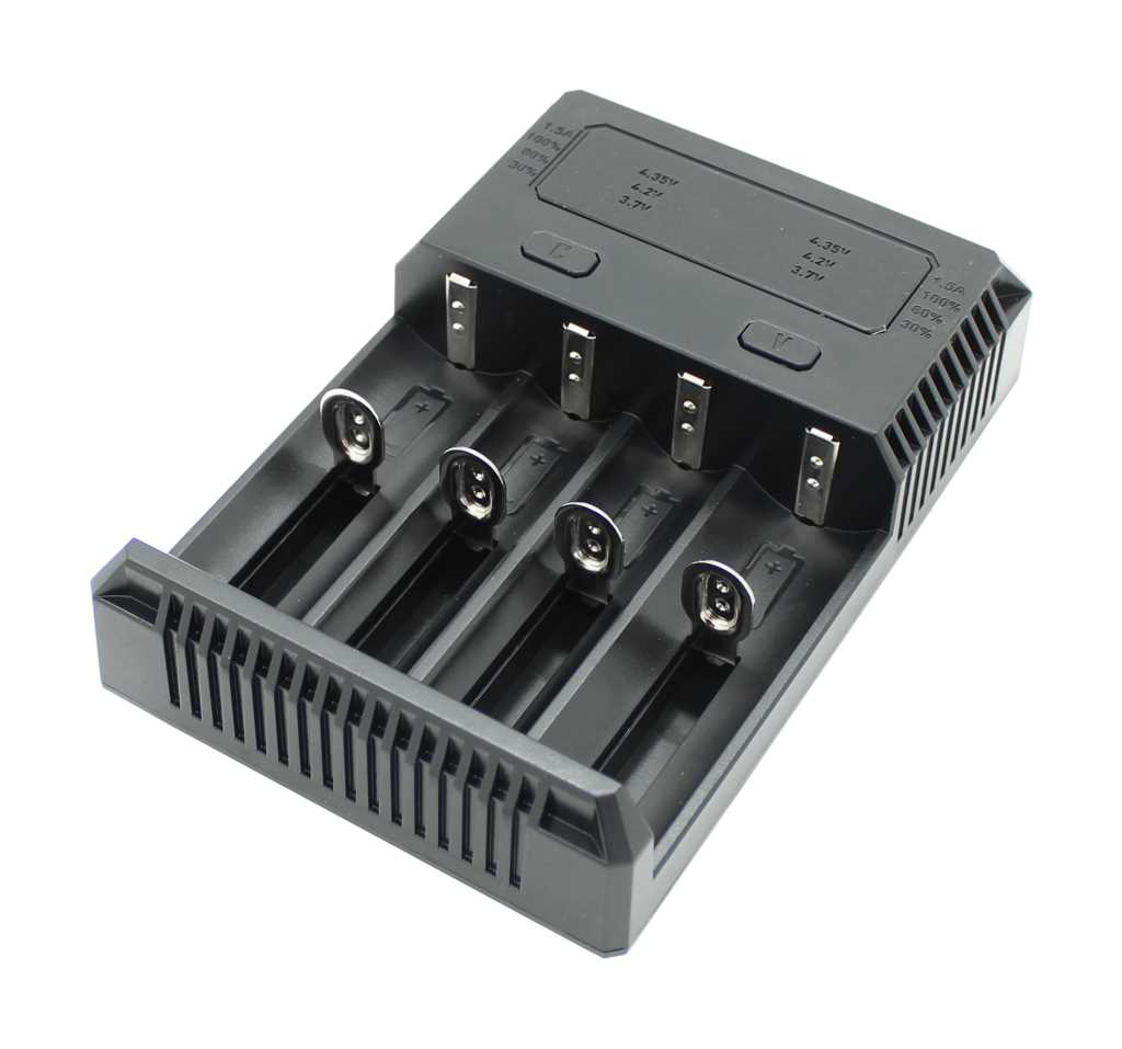 Schwarzes Ladegerät mit vier Akkuschächten und Metallkontakten, schräg von oben auf weißem Hintergrund