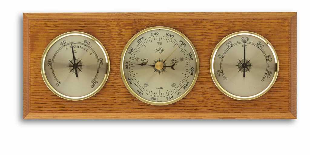 Holzbrett mit drei runden Messanzeigen mit goldfarbenem Rand, mittig größer, links und rechts kleiner angeordnet