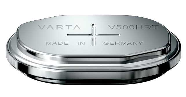 Silberne Knopfzelle in ovaler Form mit erhabener Plus-Markierung und eingravierten Buchstaben auf der Oberseite