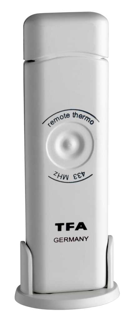 Weißes rechteckiges Gerät in Halterung mit rundem Knopf und schwarzer Aufschrift auf der Vorderseite